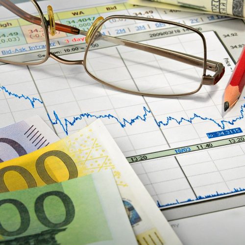 Financial charts with eyeglasses, Euro currency, and a red pencil representing P2P outsourcing services